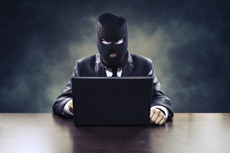 Competitor with hood in front of laptop doing click fraud