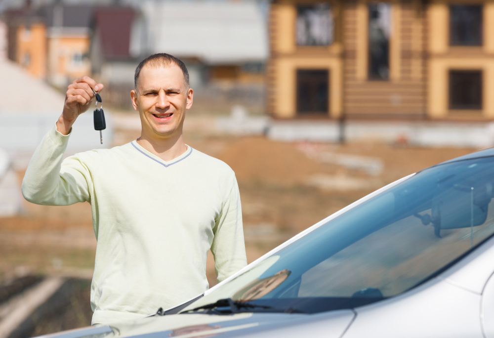 Man Holding Car Keys Background House